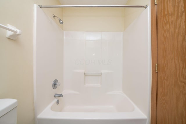 bathroom with shower / bathing tub combination and toilet