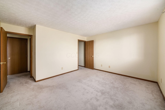 spare room with light carpet and a textured ceiling