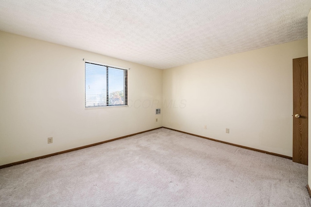 unfurnished room featuring a textured ceiling and light colored carpet