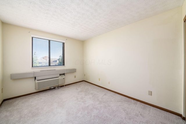 carpeted empty room with a textured ceiling and a wall unit AC