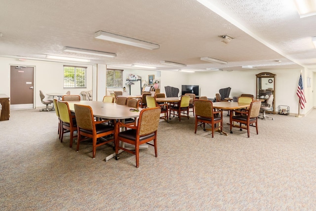 dining area with light carpet and a textured ceiling