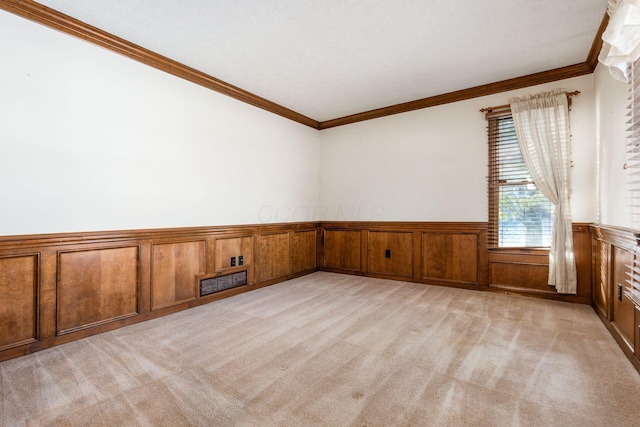 carpeted spare room featuring ornamental molding and wooden walls