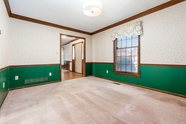 spare room with ornamental molding, carpet, and a textured ceiling