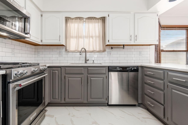 kitchen with sink, white cabinetry, appliances with stainless steel finishes, gray cabinets, and decorative backsplash