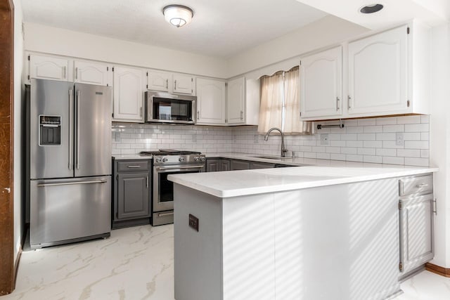 kitchen with appliances with stainless steel finishes, sink, and white cabinets