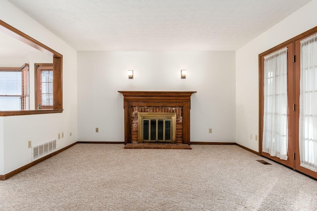 unfurnished living room with a fireplace and light carpet