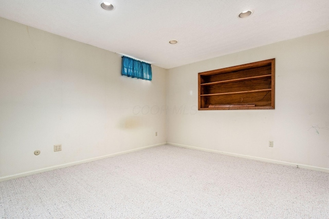 carpeted spare room with built in shelves