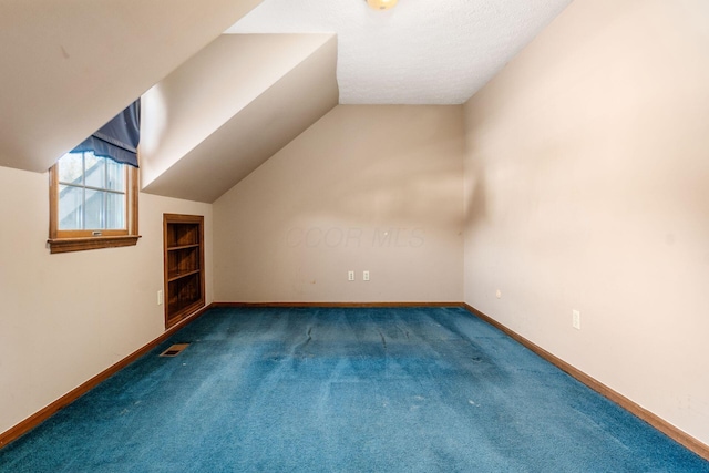 additional living space with vaulted ceiling and carpet