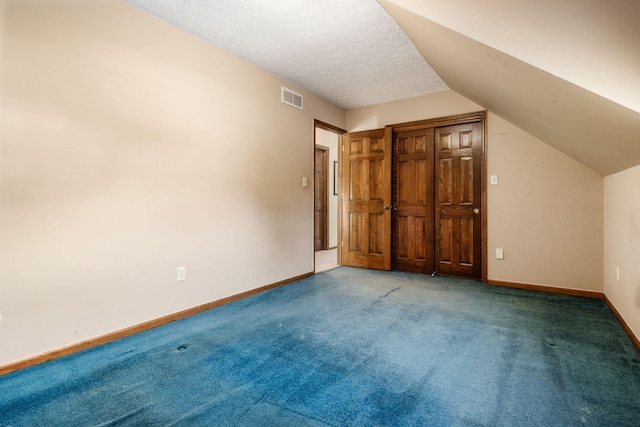 bonus room with carpet floors, a textured ceiling, and vaulted ceiling