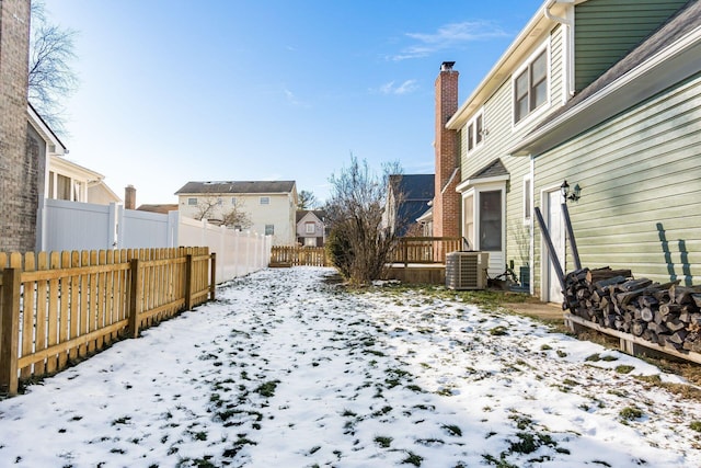 yard covered in snow with central air condition unit