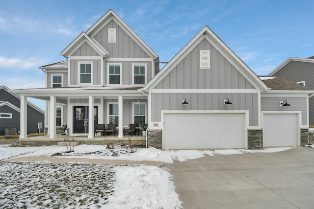 view of front of home with a garage, central AC unit, and covered porch