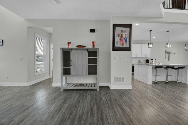 unfurnished living room featuring dark hardwood / wood-style floors and sink