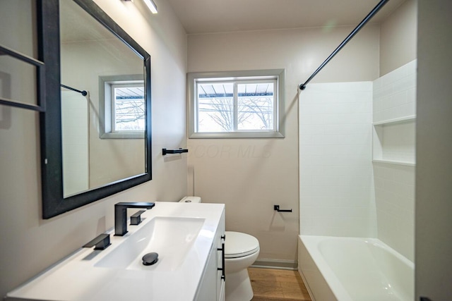 full bathroom with vanity, toilet, washtub / shower combination, and hardwood / wood-style flooring