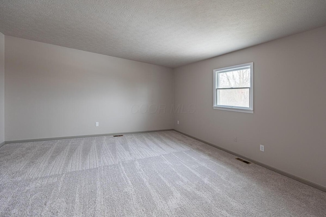 spare room with carpet floors and a textured ceiling