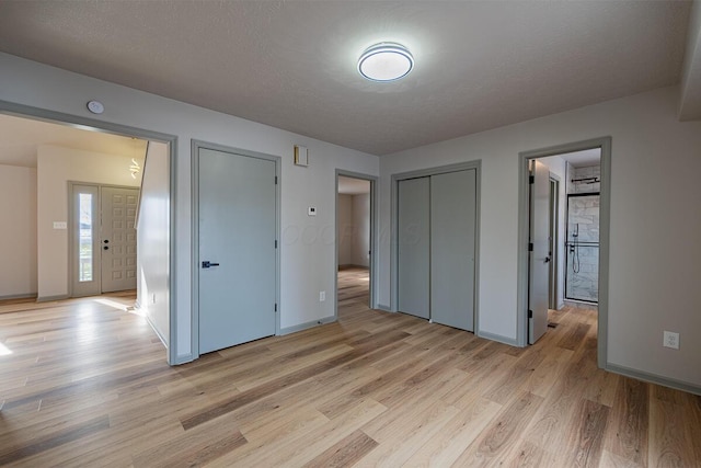 unfurnished bedroom featuring a textured ceiling and light hardwood / wood-style floors