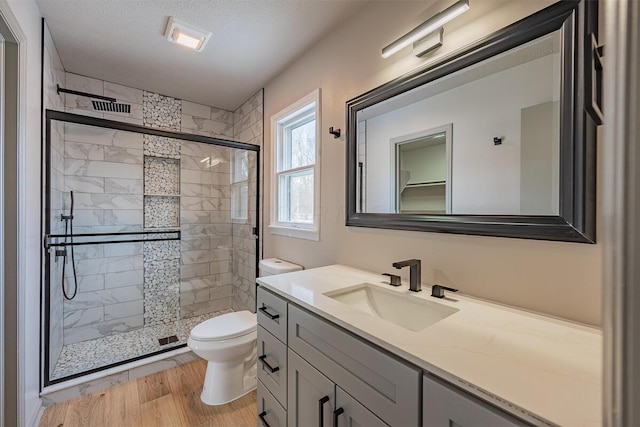 bathroom with an enclosed shower, hardwood / wood-style floors, vanity, and a textured ceiling