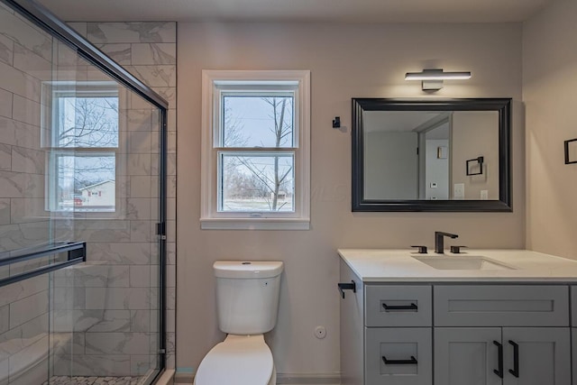 bathroom featuring walk in shower, plenty of natural light, vanity, and toilet