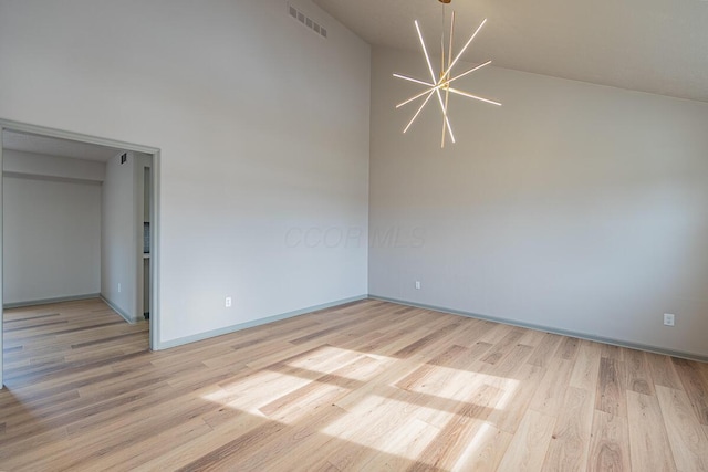 empty room with an inviting chandelier and light hardwood / wood-style floors