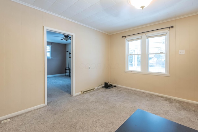 spare room featuring ornamental molding and light carpet