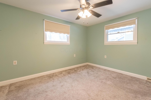 carpeted spare room with ceiling fan