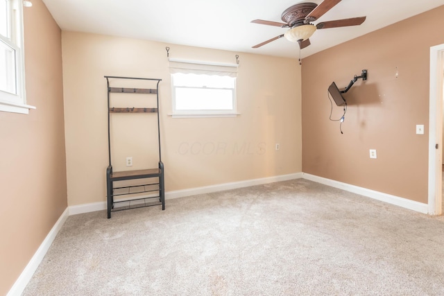 spare room featuring light colored carpet and ceiling fan