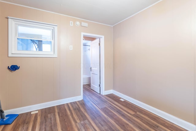 spare room featuring ornamental molding and dark hardwood / wood-style floors