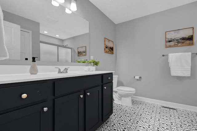 bathroom with vanity, an enclosed shower, a textured ceiling, and toilet