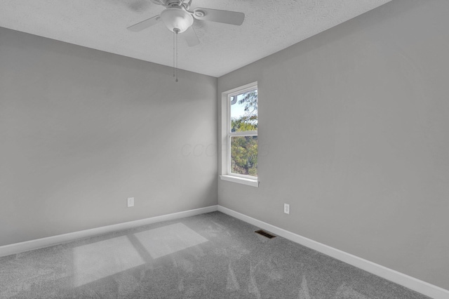 carpeted spare room with ceiling fan and a textured ceiling