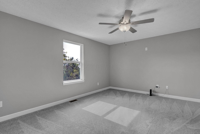 carpeted empty room with ceiling fan and a textured ceiling