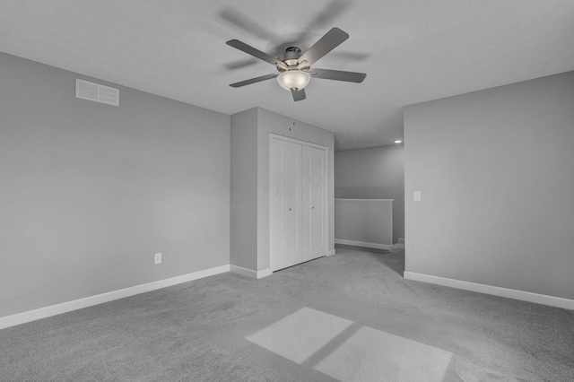 bonus room featuring ceiling fan, light colored carpet, and a textured ceiling