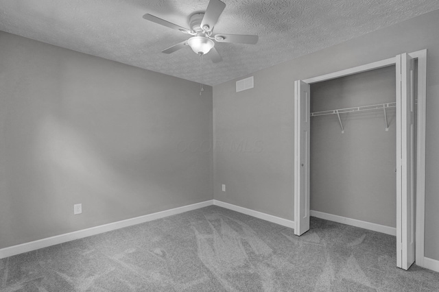 unfurnished bedroom featuring ceiling fan, carpet floors, a closet, and a textured ceiling