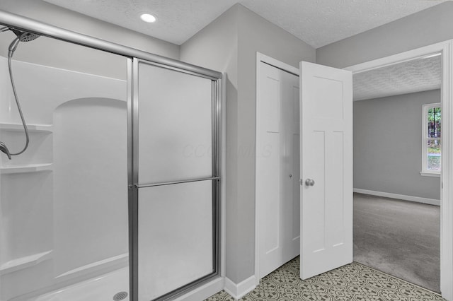 bathroom featuring an enclosed shower and a textured ceiling