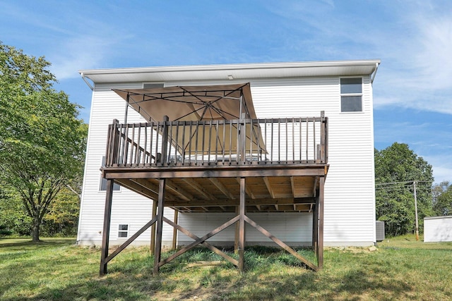 back of house featuring a deck and a lawn