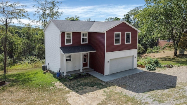 view of front of home featuring a garage, a front yard, and central AC unit