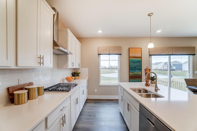 kitchen featuring sink, hanging light fixtures, stainless steel gas cooktop, white cabinets, and decorative backsplash