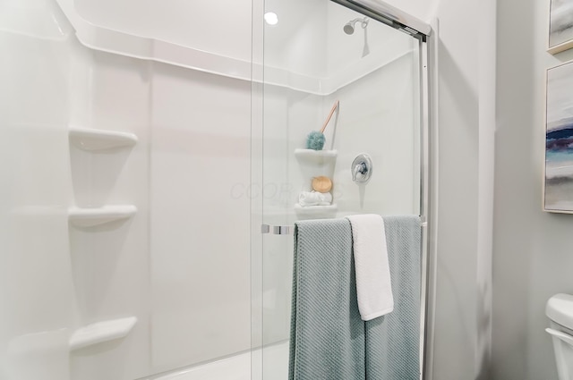 bathroom with toilet and a shower with shower door