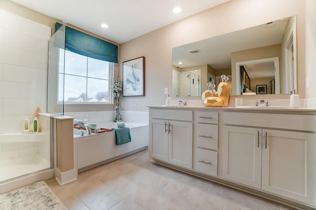 bathroom with tile patterned flooring, vanity, and separate shower and tub