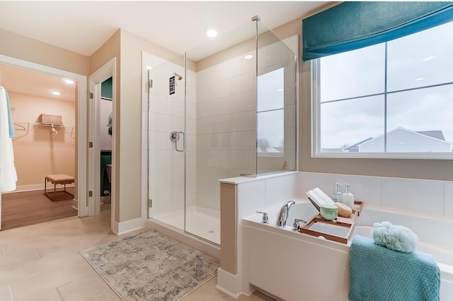 bathroom with tile patterned flooring and separate shower and tub