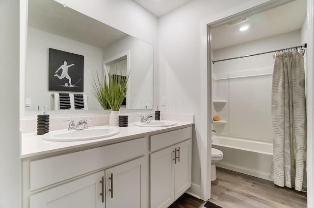 full bathroom featuring vanity, hardwood / wood-style floors, toilet, and shower / bath combo