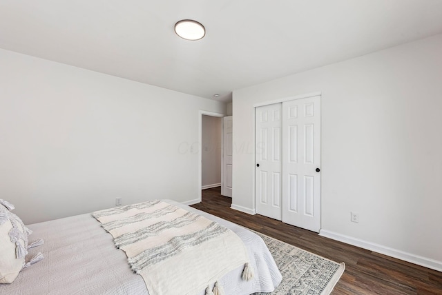 bedroom with dark wood-type flooring and a closet