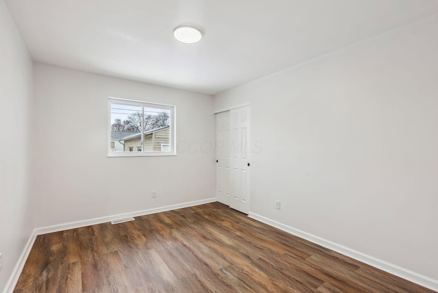 empty room with dark wood-type flooring