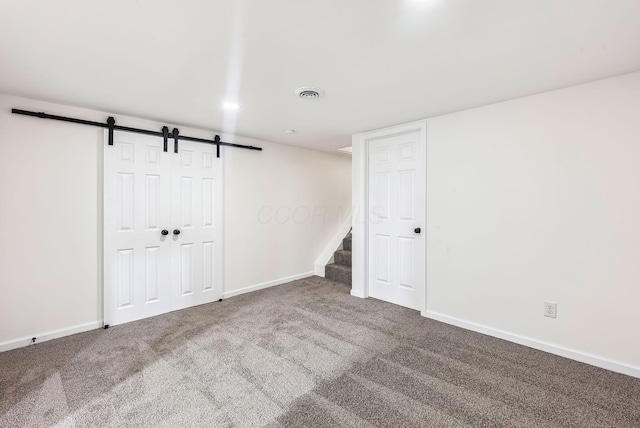 basement with carpet flooring and a barn door