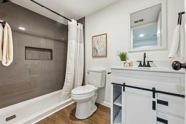 bathroom featuring wood-type flooring, a shower with shower curtain, vanity, and toilet