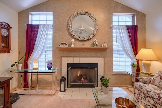 living room with a tiled fireplace and vaulted ceiling