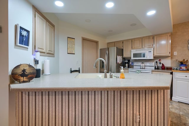 kitchen featuring white appliances, kitchen peninsula, and sink