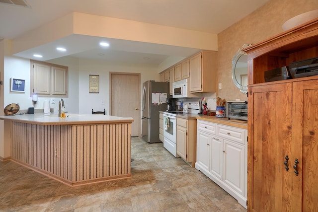 kitchen featuring sink, white appliances, and kitchen peninsula