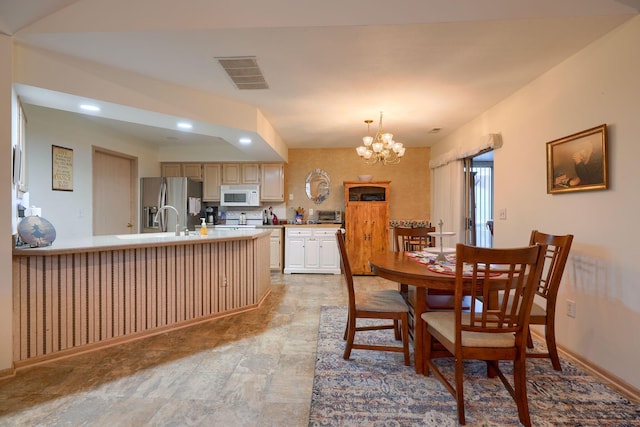 dining space with a chandelier and sink