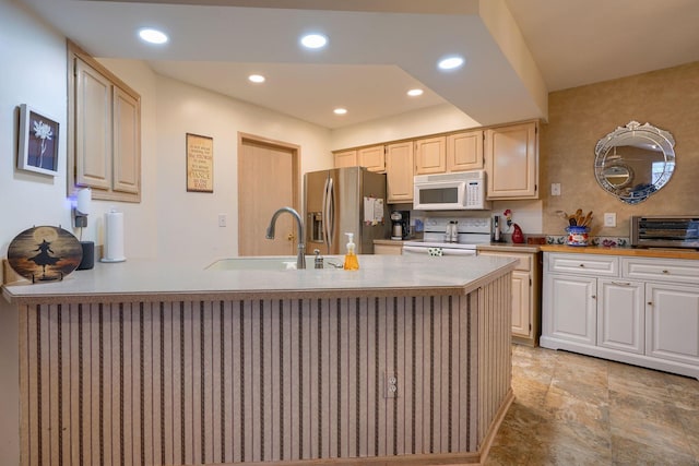 kitchen with sink, white appliances, and kitchen peninsula