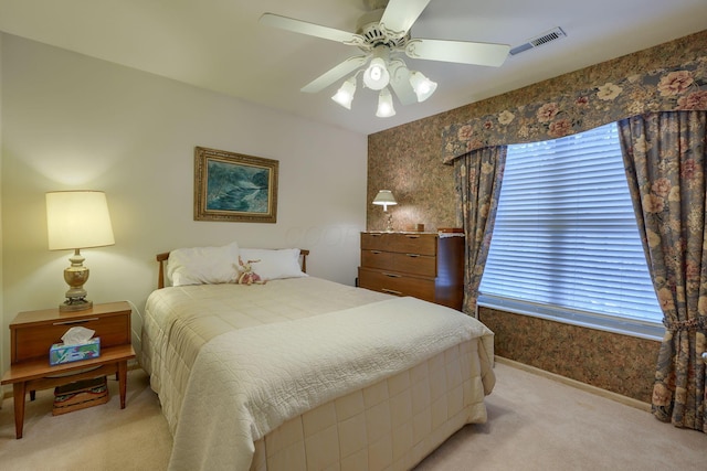 bedroom with multiple windows, light colored carpet, and ceiling fan