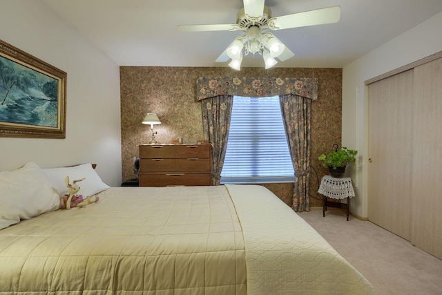 carpeted bedroom featuring ceiling fan and a closet